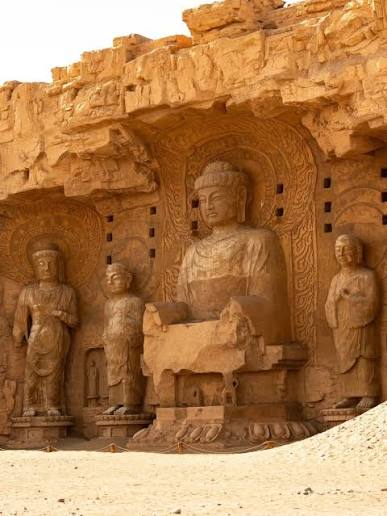 Rock-cut Buddhist figures in a desert cliff sanctuary
