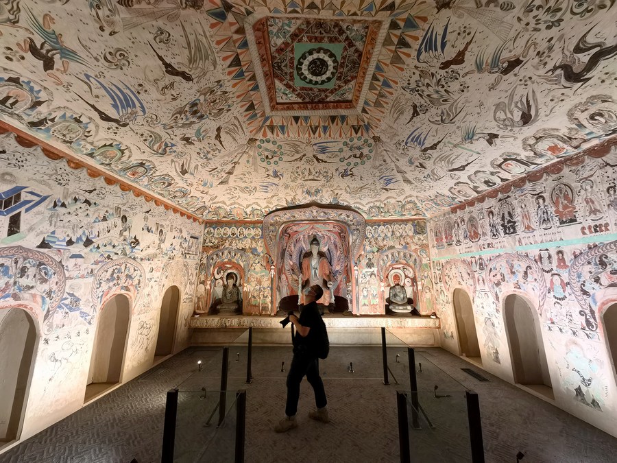 Painted Buddhist cave interior with decorated ceiling and walls