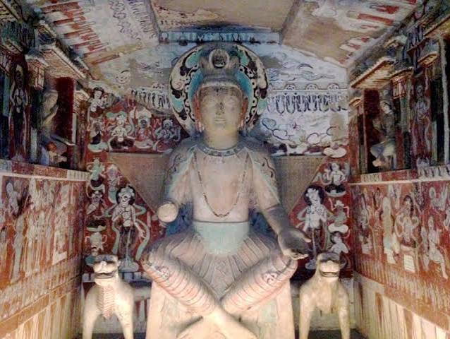 Buddhist figure in a painted cave interior