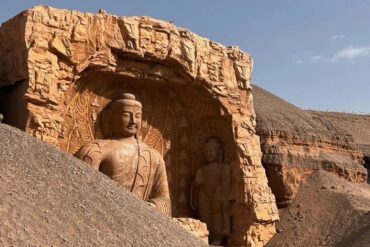 Rock-cut Buddhist figure in a desert cliff sanctuary