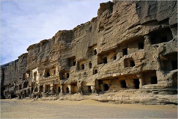Rock-cut cave openings in a weathered cliff face